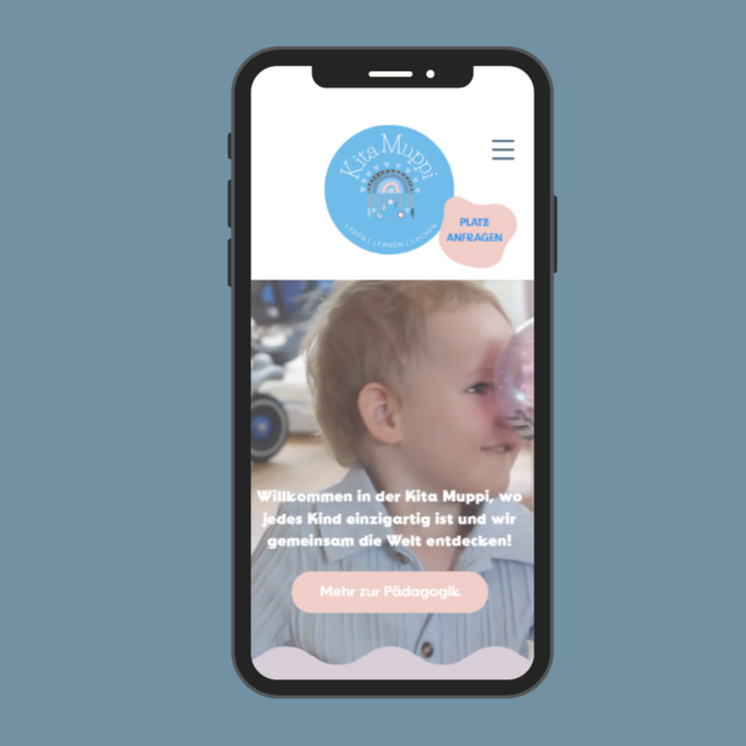 Mobile Ansicht der Kita Muppi Webseite auf einem Smartphone. Die Startseite zeigt das Logo der Kita mit dem Schriftzug 'Leben | Lernen | Lachen' und einen Button für Platzanfragen. Darunter ein Bild eines lachenden Kindes, das mit einem transparenten Ball spielt. Der Begrüssungstext hebt die Einzigartigkeit jedes Kindes hervor, begleitet von einem Button 'Mehr zur Pädagogik'.